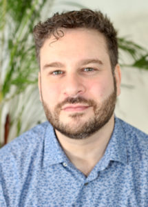 Portrait of Aryeh Lesk in blue shirt